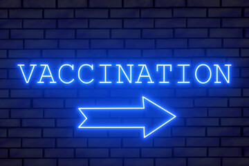 Neon sign VACCINATION on a brick wall. A neon arrow indicates a vaccination station.