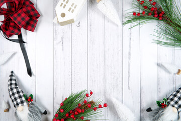Christmas Farmhouse style background styled with red plaid bows, village houses and gnomes. against...