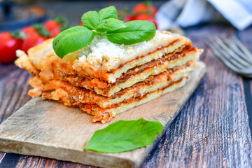   Delicious Home made  ketogenic Lasagna bolognese  with minced meat,tomato sauce and spinach  on a wooden rustic  background.Home made  keto diet italian meal
