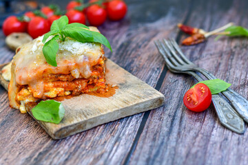   Delicious Home made Lasagna bolognese  with minced meat,tomato sauce and spinach  on a wooden rustic  background.Home made italian meal