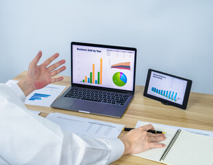 worker work with data graph on laptop and tablet on working desk