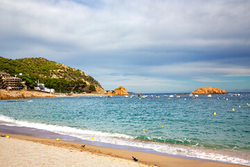 Beautiful Badia bay with rocks on Mediterranean coast in Tossa de Mar located in popular Costa Brava, Catalonia, Spain. Nice sand beach and clear blue water.