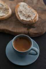 Espresso in blue cup with sandwiches with cream cheese on background