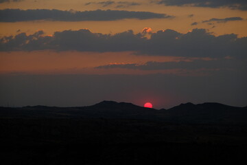 Sunset sky, red and orange sun just before evening and colorful sky in Red Valley Urgup, Goreme.