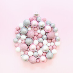 Christmas background bauble ornament frame made of various Christmas pink, silver and white balls. Monochromatic New Year aesthetic concept.