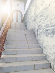 Stairs leading up to the door. Granite stairs. wide stone staircase with sunlight