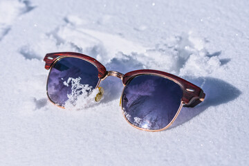 Lost tourist women's sunglasses in the snow in winter