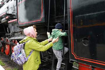 Mother helps her son get on locomotive