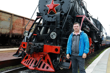Man on background of steam locomotive