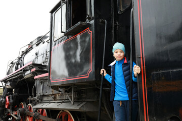 Child on step of steam locomotive