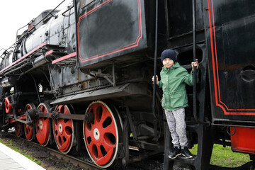 Kid on step of steam locomotive