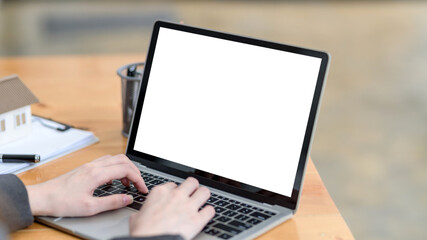 Close up. woman hand using and typing on laptop blank white screen in office. Mock up.