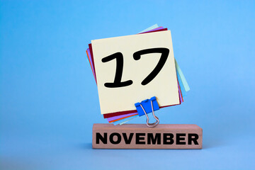 November 17th. Day 17 of November month, calendar on workplace with blue background. Autumn time.