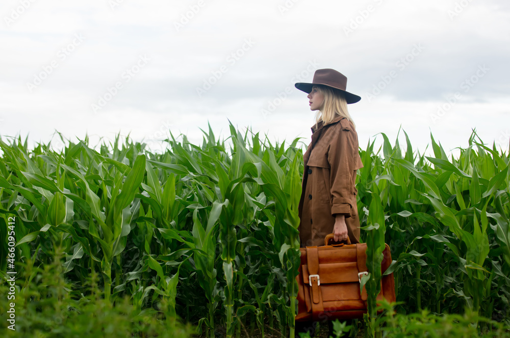 Canvas Prints Blonde woman in cloak and hat with suitcase in cornfield in summertime