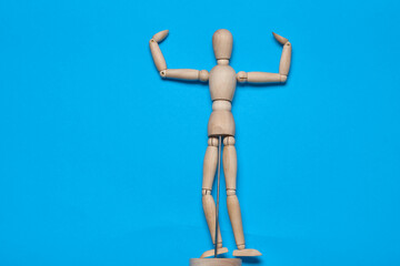 wooden figure mannequin object posing blue background