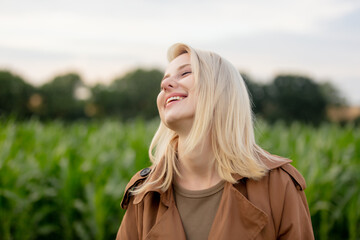 Blonde woman in cloak in cornfield in summertime