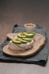 Avocado sandwiches with espresso for breakfast on walnut wood table