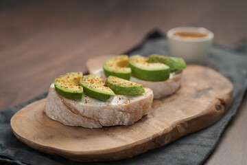 Avocado sandwiches with espresso for breakfast on walnut wood table