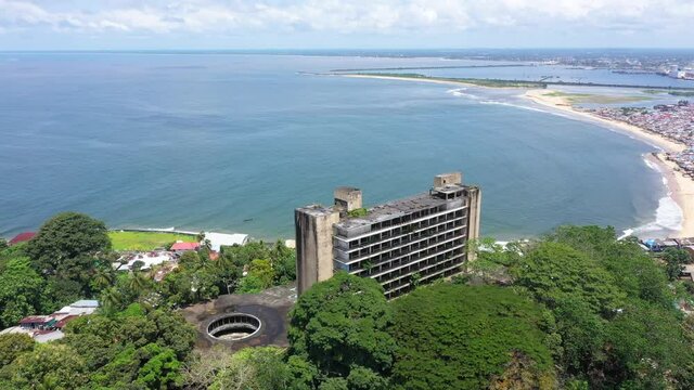 Aerial abandoned resort hotel Monrovia Liberia circle part 2. West Africa suffers extreme poverty and hunger. Civil war, EBOLA and COVID destruction. Crowded homes and businesses.