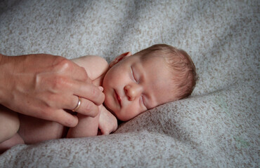 sleeping baby and mother's hand with wedding ring