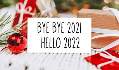 Merry christmas and merry new year concept with gift boxes and greeting card with text hello 2022...