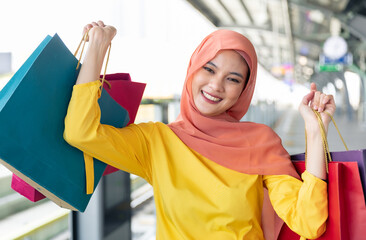Arabic women shopping outdoors Girls with traditional arabian dress.Modern Lifestyle of Arab Muslim young woman in veil hijab with shopping bags walking on the shopping street phone calling.