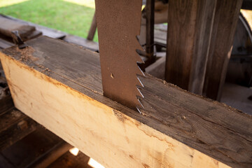 Vertical saw blade cuts lumber in a colonial sawmill