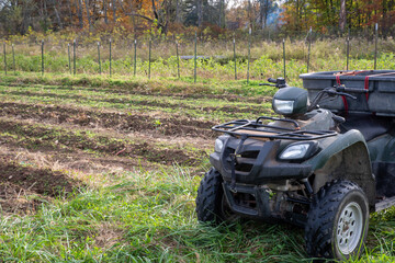 Off road vehicle by a vegetable garden with autumn trees background © Mary Salen