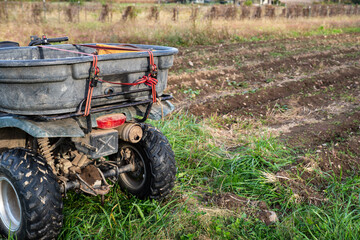 Obraz premium Closeup of hauling bin strapped to a farm ATV by a new garden