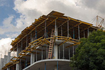 Multi-level commercial high-rise building construction with blue sky