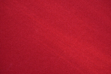 Red velvet paper background in the rays of the sun