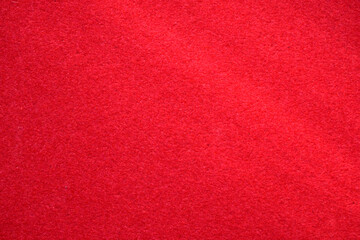 Red velvet paper background in the rays of the sun