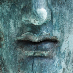 Human face made of rough stone. Bust of turquoise color close up