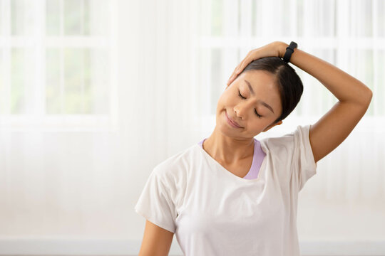 Asian woman exercises In the fitness studio, practice neck stretching and meditation for better health.