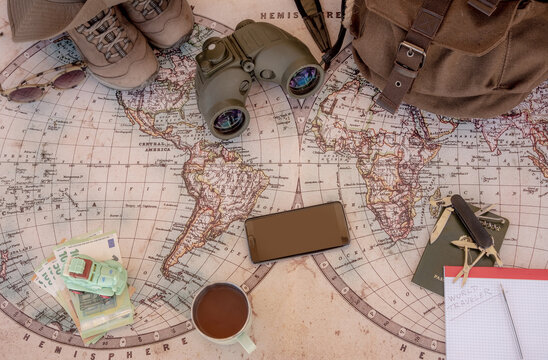 Old map to planning a world trip, travel, journey.  Personal accessories such as backpack and hat, money and identity document