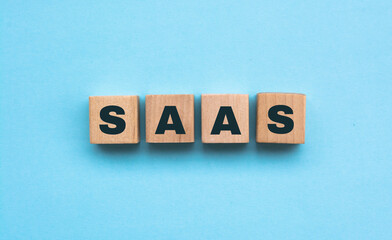 SAAS text on wooden cubes on blue background - Image