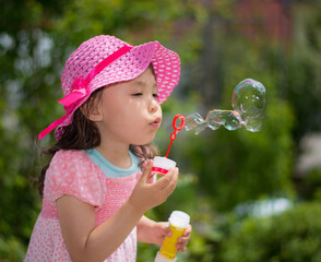 little girl blowing soap bubbles