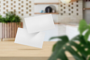 Clean minimal business card mockup on top table in soft cafe with leaves