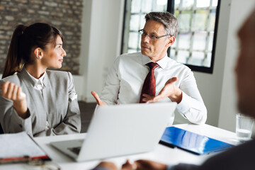 Obraz premium Business people talking to each other while having a business meeting in the office