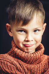 portrait of an offended boy on a dark background