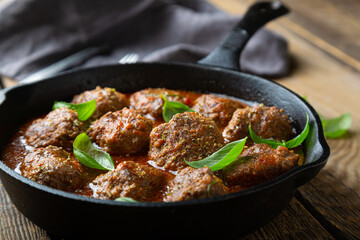 Homemade meatballs in tomato sauce with fresh basil