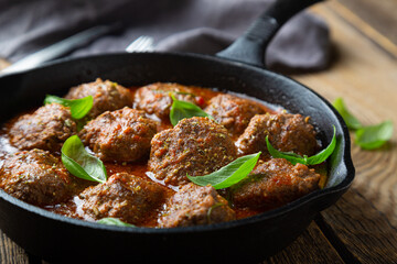Homemade meatballs in tomato sauce with fresh basil