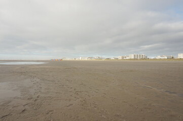 White Buildings of Resort Town on Horizon of Beach with Colored Lockers and Blue Sky