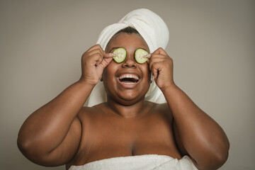 Happy curvy African woman having skin care spa day - People wellness and self care lifestyle concept
