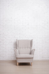 Armchair with copy space over white brick wall