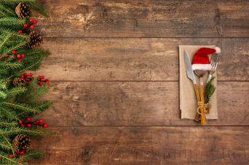 Festive New Year Christmas dinner concept. Christmas decorations and Cutlery on dark rustic table....