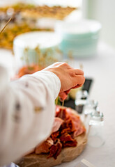 Obraz premium woman hands of a waiter prepare food for a buffet table in a restaurant