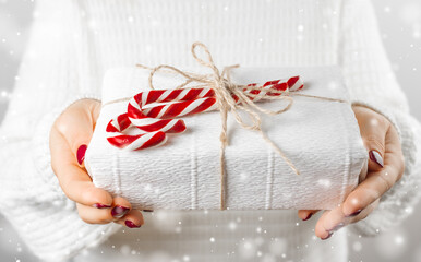 Giving gift, handmade present wrapped in paper. Hands with a gift, close up