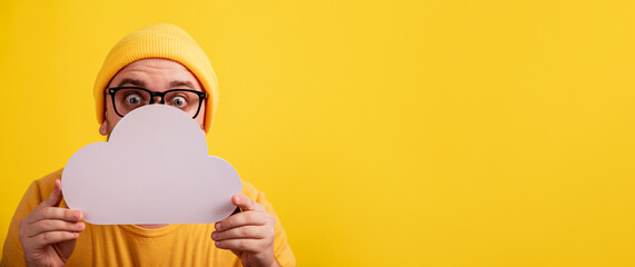 caucasian man holding storage cloud over yellow background, panoramic layout