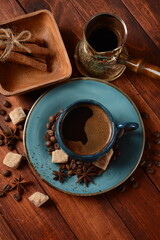 Coffee cup, demerara brown sugar cubes ,  сezve and beans on old kitchen table